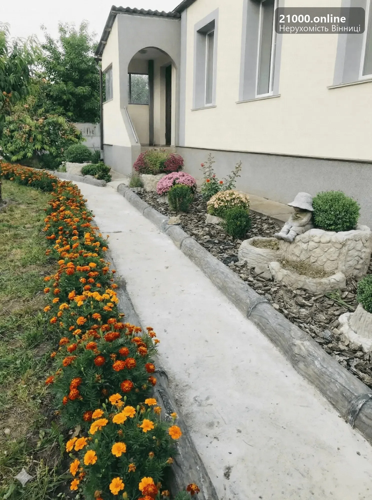 Доглянуте подвір'я з ландшафтним дизайном та бетонними доріжками